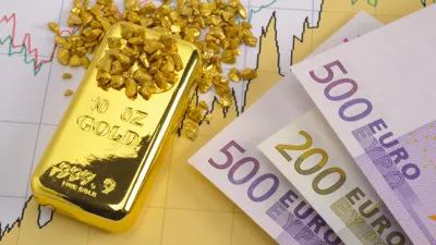 gold bar and European currency laying on chart of stock market