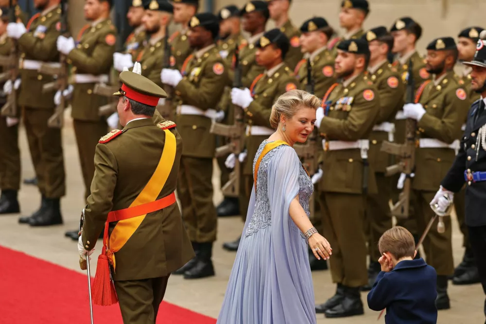 Luxembourg's Prince Charles tries to block out the noise, as Grand Duke Guillaume walks near his wife Grand Duchess Stephanie, after the Grand Duke was sworn-in, in Luxembourg, October 3, 2025. REUTERS/Kai Pfaffenbach