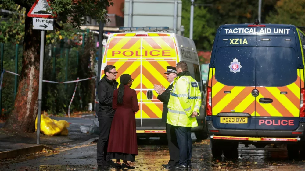 Britain's Conservative Party leader Kemi Badenoch stands with Mayor of Greater Manchester Andy Burnham and Assistant Chief Constable John Webster, as she makes a visit to the site near the Manchester synagogue, where multiple people were killed on Yom Kippur, in what police have declared a terrorist incident, in north Manchester, Britain, October 4, 2025. REUTERS/Temilade Adelaja