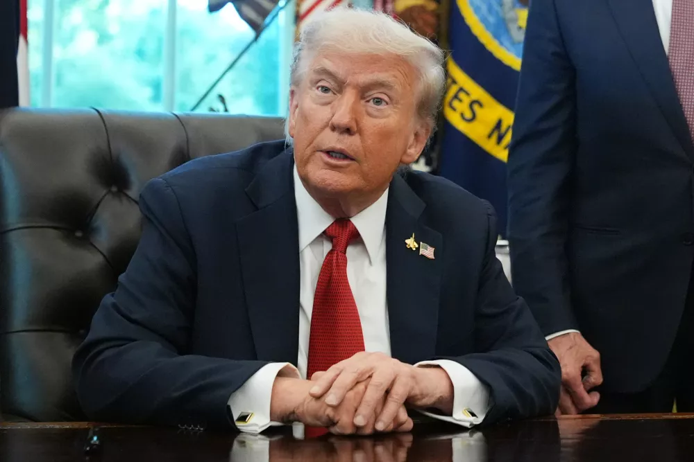 President Donald Trump speaks to reporters before signing an executive order in the Oval Office at the White House, Monday, Oct. 6, 2025, in Washington. (AP Photo/Jacquelyn Martin)