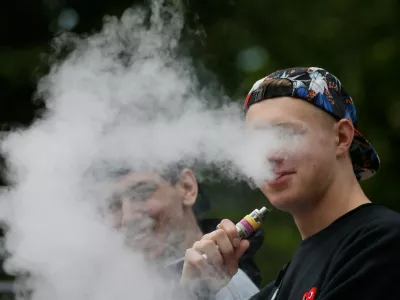 A man exhales electronic cigarette vapour in a park in central Kiev, Ukraine May 12, 2017. REUTERS/Valentyn Ogirenko - RC1445F0D830