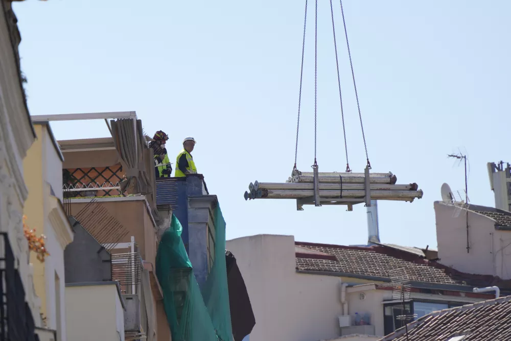 Rescue workers stand on the roof at the scene of a building collapse in Madrid, Spain, on Tuesday, Oct. 7, 2025. (AP Photo/Manu Fernandez)