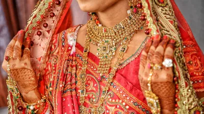 Indijsko nevesto med poročnim obredom krasi zlat nakit. f iStock