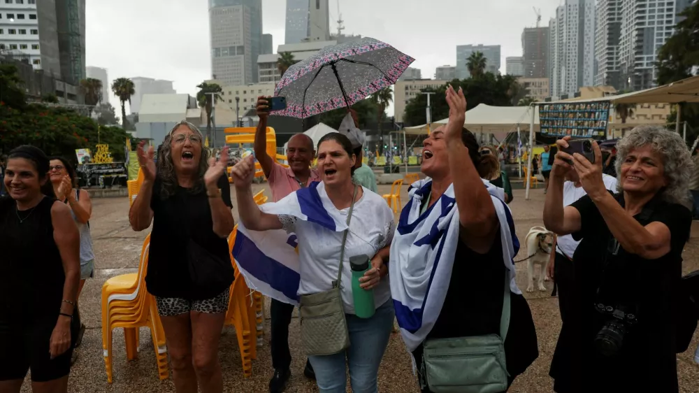 People celebrate after U.S. President Donald Trump announced that Israel and Hamas agreed on the first phase of a Gaza ceasefire, at the "Hostages square", in Tel Aviv, Israel, October 9, 2025. REUTERS/Ronen Zvulun