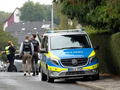 Police officers across a street in Herdecke, Germany, Tuesday, Oct. 7, 2025, after the newly elected mayor of Herdecke, Iris Stalzer, has been found critically injured in her apartment. (AP Photo/Martin Meissner)