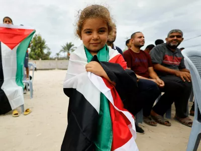 A girl holds a Palestinian flag, after U.S. President Donald Trump announced that Israel and Hamas agreed on the first phase of a Gaza ceasefire, in the central Gaza Strip October 9, 2025. REUTERS/Mahmoud Issa   TPX IMAGES OF THE DAY