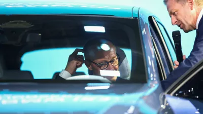 German Chancellor Friedrich Merz gestures as BMW Group CEO Oliver Zipse shows him a BMW iX3 at the IAA Mobility 2025 auto show in Munich, Germany, September 9, 2025. REUTERS/Kai Pfaffenbach