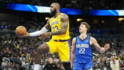 Los Angeles Lakers forward LeBron James (23) passes the ball as he gets past Orlando Magic forward Franz Wagner (22) during the first half of an NBA basketball game, Monday, March 24, 2025, in Orlando, Fla. (AP Photo/John Raoux)