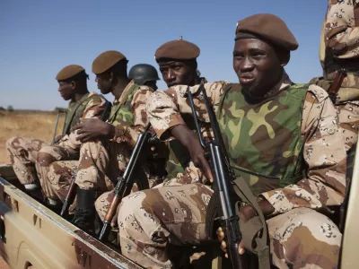 Malian soldiers look on as Mali's President Dioncounda Traore visits French troops at an air base in Bamako, Mali January 16, 2013. REUTERS/Joe Penney (MALI - Tags: MILITARY POLITICS)