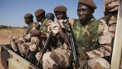 Malian soldiers look on as Mali's President Dioncounda Traore visits French troops at an air base in Bamako, Mali January 16, 2013. REUTERS/Joe Penney (MALI - Tags: MILITARY POLITICS)