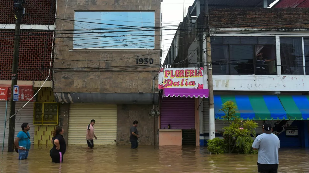 People wade through a flooded street after torrential rains that caused an overflow of rivers in Poza Rica, Veracruz state, Mexico, October 10, 2025. REUTERS/Rolando Ramos   TPX IMAGES OF THE DAY