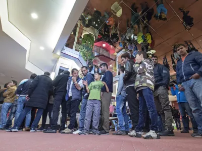 People line up for their meal in the initial reception center for asylum seekers in Halle/Saale, Germany, Friday, Oct. 16, 2015. The center in a former hotel has capacity for around 700 refugees. (AP Photo/Jens Meyer)