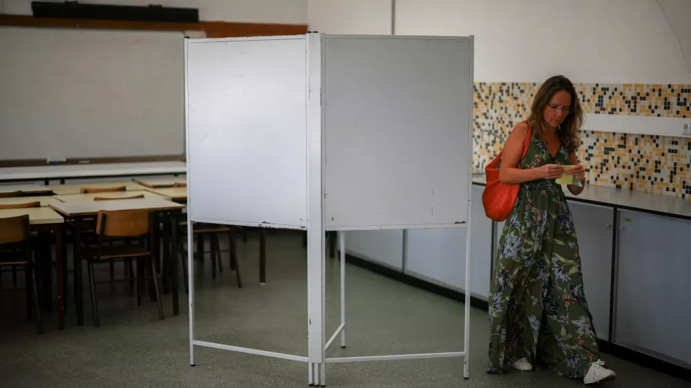 A voter folds a ballot at a polling station during the local election in Lisbon, Portugal, October 12, 2025. REUTERS/Pedro Nunes