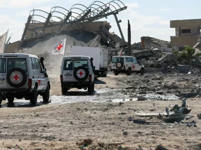 Red Cross vehicles escort a truck transporting the bodies of Palestinians who had been held in Israel during the war, amid a ceasefire between Israel and Hamas, in Khan Younis in the southern Gaza Strip, October 14, 2025. REUTERS/Ramadan Abed   TPX IMAGES OF THE DAY