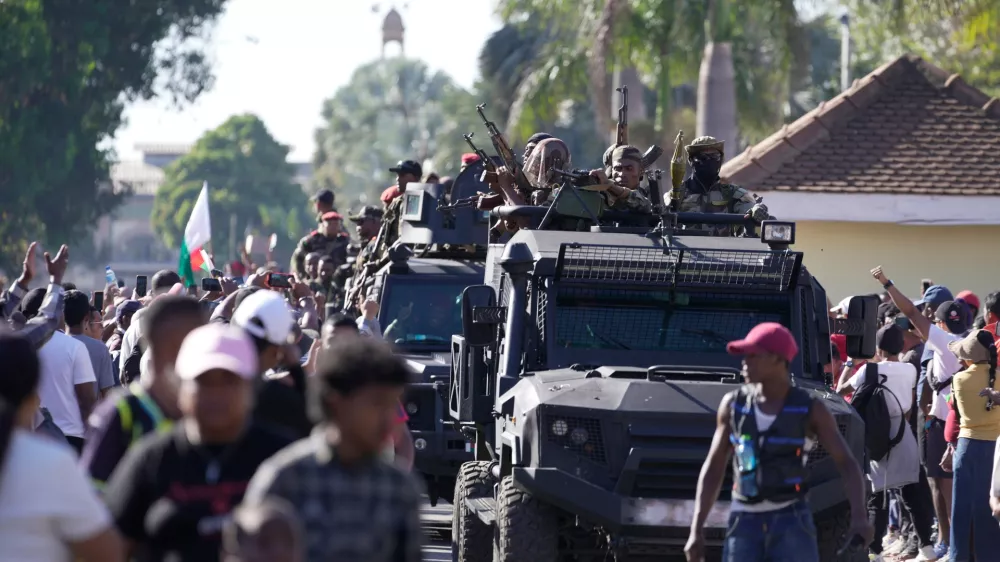 Troops loyal to CAPSAT military unit commander Col. Michael Randrianirina make their way to the Presidency to announce that the armed forces are taking control of the country in Antananarivo, Madagascar, Tuesday, Oct. 14, 2025. (AP Photo/ Brian Inganga)