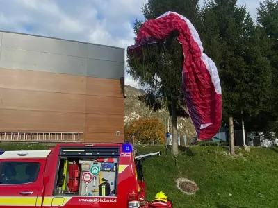 Jadralna padalka je obvisela na smreki. 