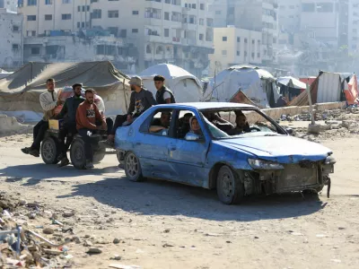 Palestinians in a car pull a cart with people on it, while driving near tents, amid a ceasefire between Israel and Hamas, in Gaza City, October 15, 2025. REUTERS/Dawoud Abu Alkas