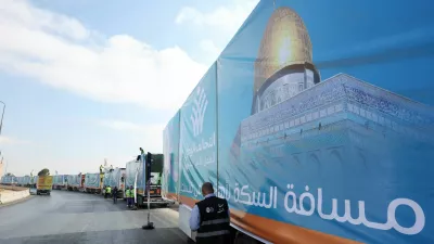 A man walks next to trucks loaded with humanitarian aid from Egypt's National Alliance For Civil Development Work (NACDW) as they are on their way to the Rafah border crossing to enter Gaza, after a ceasefire between Israel and Hamas in Gaza went into effect, on the Cairo-Ismailia desert road, in Egypt, October 16, 2025. REUTERS/Amr Abdallah Dalsh