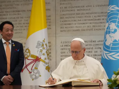 Pope Leo XIV signs a gold book as he attends at the Global World Food Day Ceremony in Rome, Thursday, Oct. 16, 2025. (AP Photo/Alessandra Tarantino)