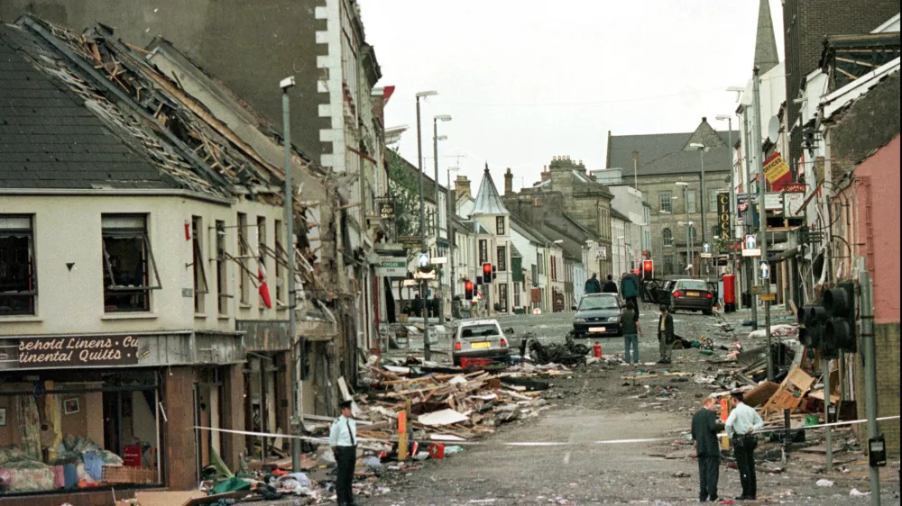 FILE - Royal Ulster Constabulary Police officers stand on Market Street, the scene of a car bombing in the centre of Omagh, Co Tyrone, 72 miles west of Belfast, Northern Ireland, on Aug. 15, 1998. (AP Photo/Paul McErlane, File)