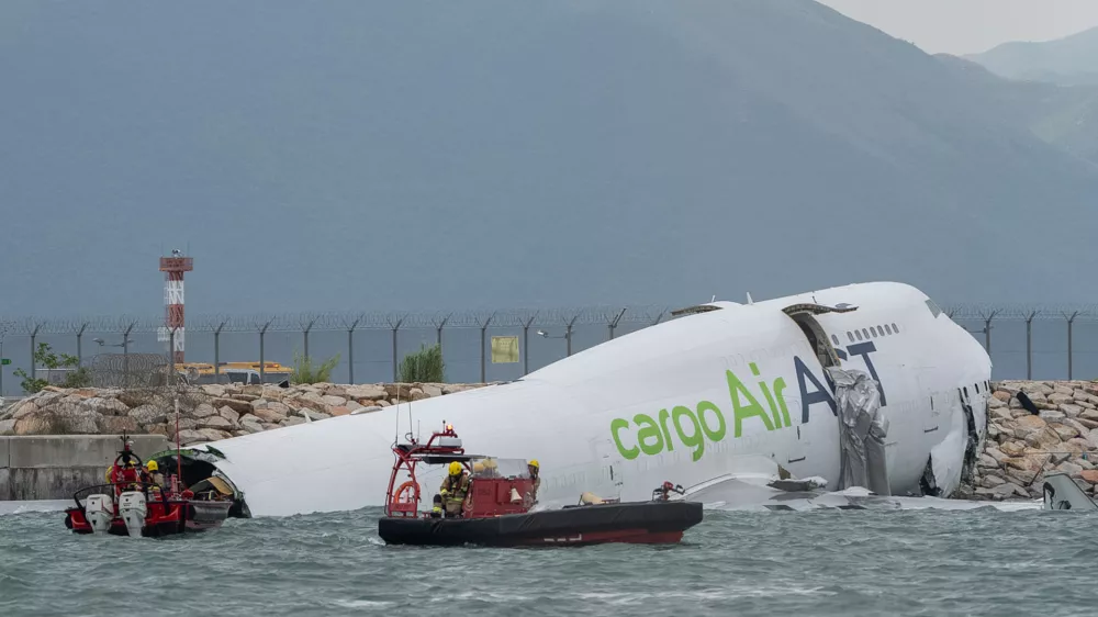 Responders on boats float around the cargo aircraft that skidded off a Hong Kong runway on Monday, Oct. 20, 2025. (AP Photo/Chan Long Hei)