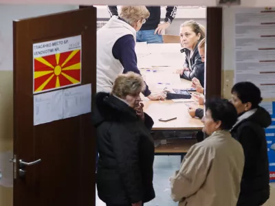 People wait to enter a polling station prior voting for the local elections, in Skopje, North Macedonia, on Sunday, Oct. 19, 2025. (AP Photo/Boris Grdanoski)