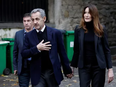 Former French President Nicolas Sarkozy leaves his house with his wife Carla Bruni-Sarkozy on the day of his incarceration at the Sante prison to begin his five-year prison sentence for criminal conspiracy over attempts to raise campaign funds from Libya, in Paris, France, October 21, 2025. REUTERS/Benoit Tessier