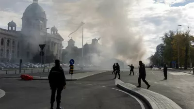 Police officers secure the area as smoke rises from a burning tent following an incident in front of the Parliament in Belgrade, Serbia, October 22, 2025. REUTERS/Djordje Kojadinovic