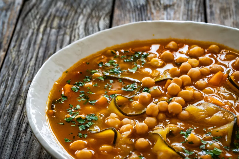 Fresh vegetable soup with chickpeas, zucchini and sweet potatoes on wooden table / Foto: Gbh007