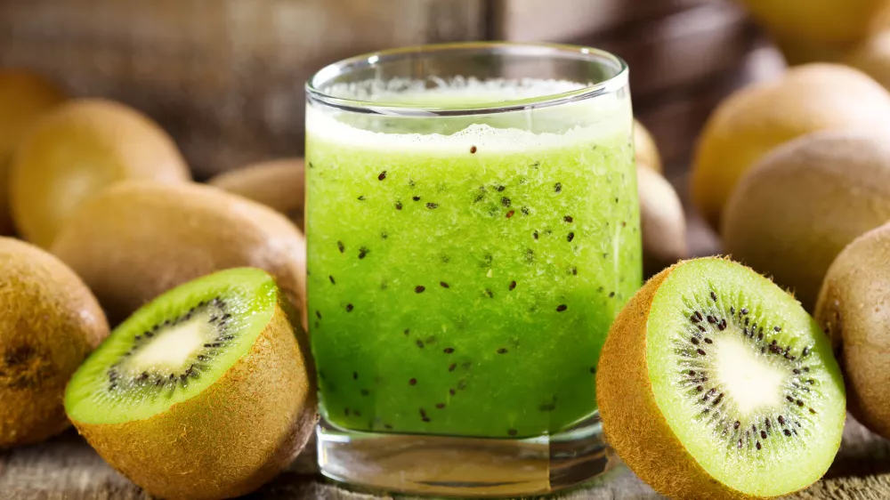 glass of kiwi juice with fresh fruits on wooden table / Foto: Nitrub