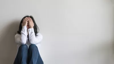 Anxiety disorder menopause woman, stressful depressed emotional person with mental health illness, headache and migraine sitting feeling bad sadly with back against wall on the floor in domestic home / Foto: Chinnapong