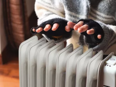 Person heating their hands at home over a domestic portable radiator in winter / Foto: Tennessee Witney