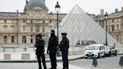 Police officers stand near the pyramid of the Louvre museum after reports of a robbery, in Paris, France, October 19, 2025. REUTERS/Gonzalo Fuentes   TPX IMAGES OF THE DAY