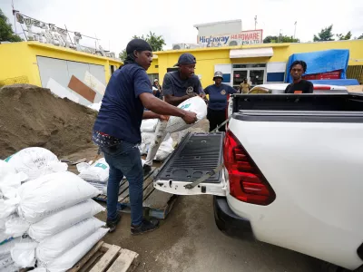 People load a sandbag onto a vehicle, in preparation for the arrival of Hurricane Melissa, in the Harbour View neighbourhood of Kingston, Jamaica, October 25, 2025. REUTERS/Octavio Jones