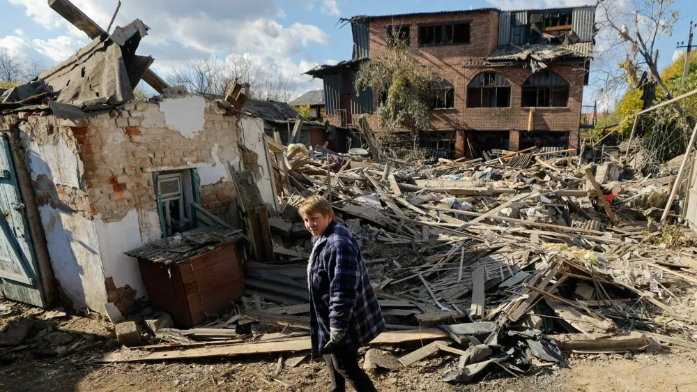 Oksana Lavrenteva, 52, walks past rubble of her house following what Russian-installed authorities described as an overnight Ukrainian missile strike, amid the Russia-Ukraine military conflict in Yasynuvata (Yasinovataya) in the Donetsk region, a Russian-controlled area of Ukraine, October 26, 2025. REUTERS/Alexander Ermochenko