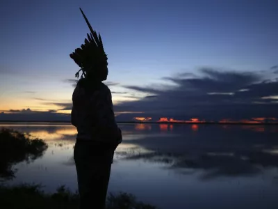 Robson Mura, of the Mura Indigenous community, watches the sunrise at the Moyray village in Autazes, Amazonas state, Brazil, Friday, Feb. 21, 2025. (AP Photo/Edmar Barros)