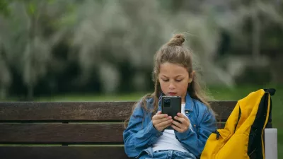 Beautiful little boy using smart phone in the park. / Foto: Jose Luis Carrascosa