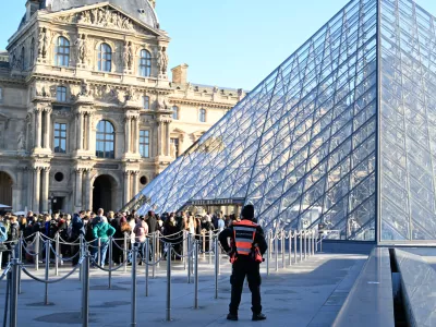 People queue to enter the Louvre museum, Thursday, Oct. 30, 2025 in Paris. (AP Photo/Emma Da Silva)