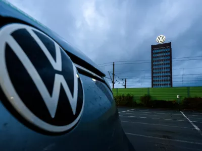 30 October 2025, Lower Saxony, Wolfsburg: A Volkswagen parked in front of the Volkswagen brand tower at the site of the VW main plant. Photo: Julian Stratenschulte/dpa