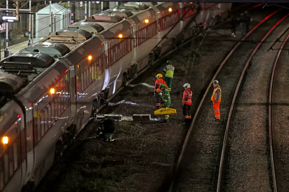 Emergency personnel inspect a train at the Huntingdon, England, train station in Cambridgeshire after people were stabbed Saturday, Nov. 1, 2025. (Chris Radburn/PA via AP)