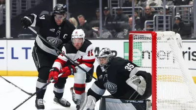 Los Angeles Kings center Anze Kopitar, left, New Jersey Devils right wing Stefan Noesen (11), and Los Angeles Kings goaltender Darcy Kuemper (35) battle for the puck during the first period of an NHL hockey game, Saturday, Nov. 1, 2025, in Los Angeles. (AP Photo/Jessie Alcheh)