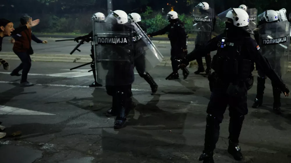 Serbian riot police separate rival crowds of opponents, right, and loyalists of autocratic President Aleksandar Vucic, a day after tens of thousands of people joined a huge rally in the northern city of Novi Sad marking the first anniversary of a train station disaster there that killed 16 people, in Belgrade, Serbia, Sunday, Nov. 2, 2025. (AP Photo/Marko Drobnjakovic)