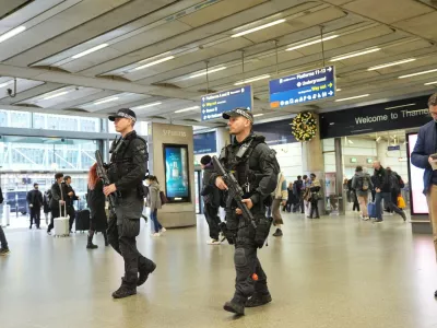 Armed police officers go on patrol at St Pancras International train station in London, England, Monday, Nov. 3, 2025. (Yui Mok/PA via AP)