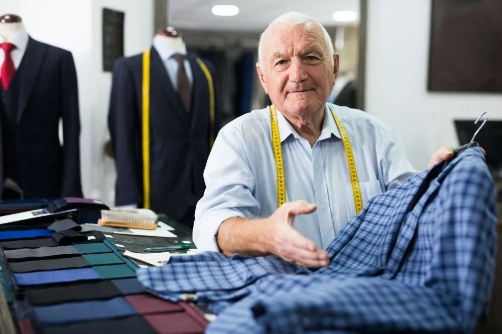 Male tailor demonstrating of fashionable suit in apparel shop,Image: 851698754, License: Royalty-free, Restrictions:, Model Release: yes