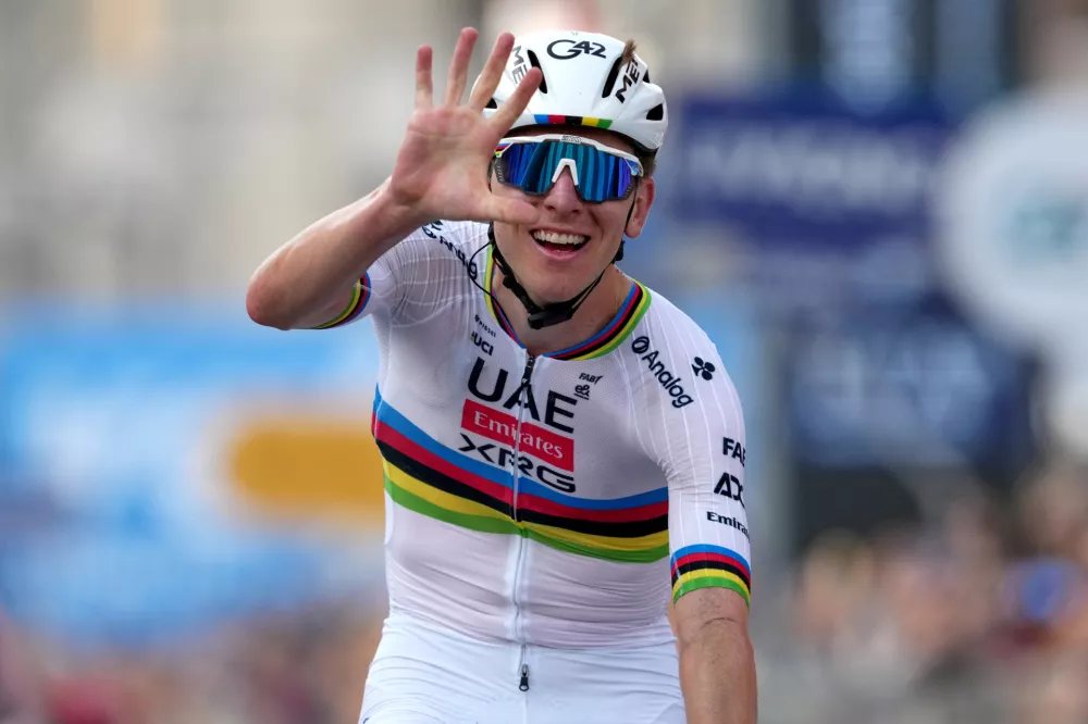 Reigning World Champion Tadej Pogacar indicates five as he celebrates winning his fifth in a row Il Lombardia, Tour of Lombardy cycling race, in Bergamo, Italy, Saturday, Oct. 11, 2025. (Gian Mattia D'Alberto/LaPresse via AP)