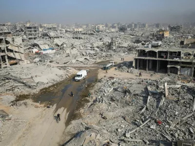 Palestinians walk past the rubble of destroyed buildings, amid a ceasefire between Israel and Hamas, in Gaza City, November 5, 2025. REUTERS/Dawoud Abu Alkas