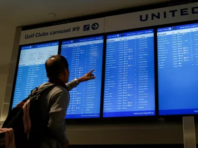 FILE PHOTO: Travelers look upon a flight-arrival screen at Newark Liberty International Airport in Newark, New Jersey, U.S., August 6, 2025. REUTERS/Ryan Murphy/File Photo