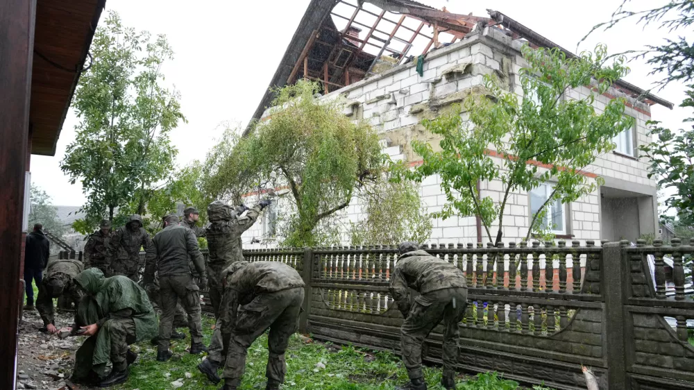 FILE - Territorial defense officers clean up debris from the destroyed roof of a house in Wyryki near Lublin, Poland, after Russian drones violated Polish airspace during an attack on Ukraine, on Sept. 11, 2025. (AP Photo/Czarek Sokolowski, File)