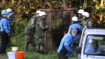 Japan Ground Self-Defense Force members and others set up a box trap to capture bears in Kazuno, Akita prefecture, northern Japan Wednesday, Nov. 5, 2025. (Muneyoshi Someya/Kyodo News via AP)