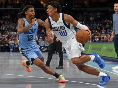 Nov 7, 2025; Memphis, Tennessee, USA; Dallas Mavericks guard Max Christie (00) drives to the basket against Memphis Grizzlies guard Ja Morant (12) during the fourth quarter at FedExForum. Mandatory Credit: Petre Thomas-Imagn Images
